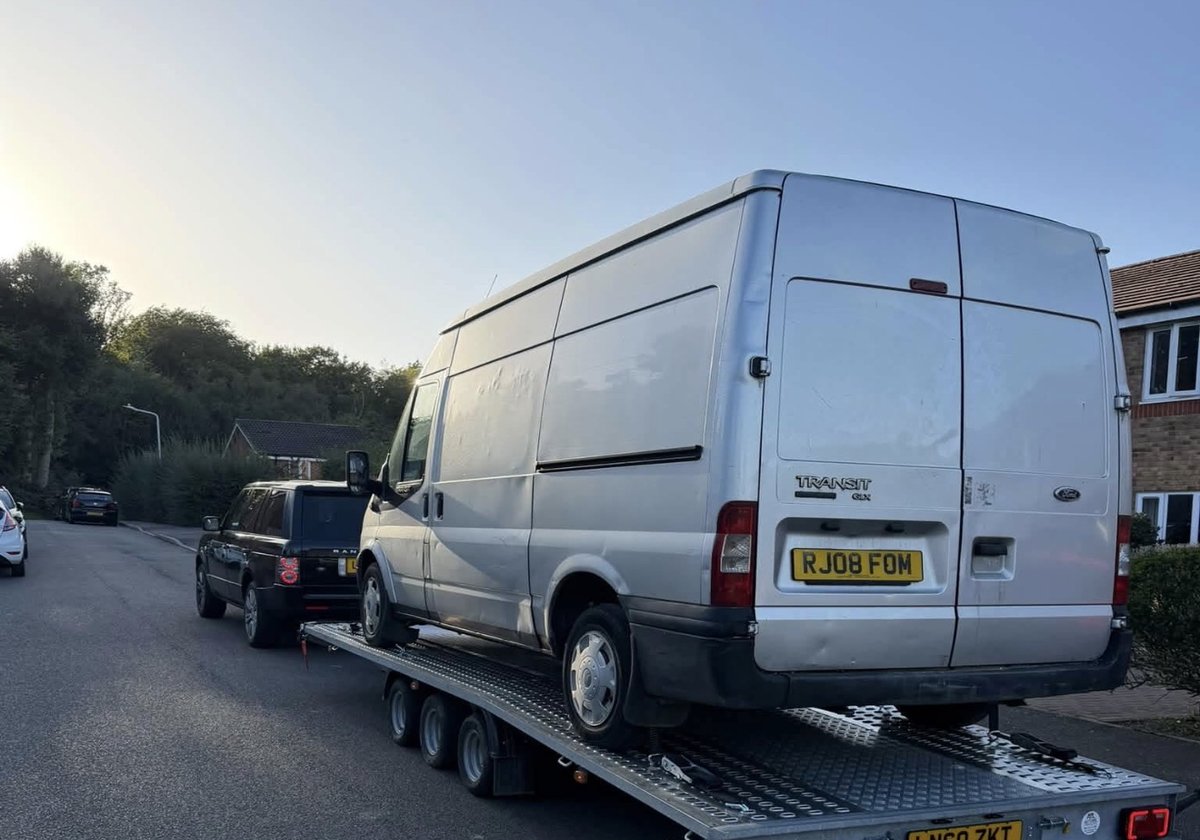Silver Ford Transit high-roof van recovered onto the flatbed transporter trailer